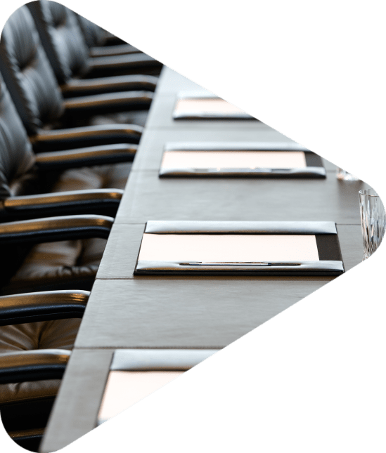 boardroom table with neatly placed papers and water glasses