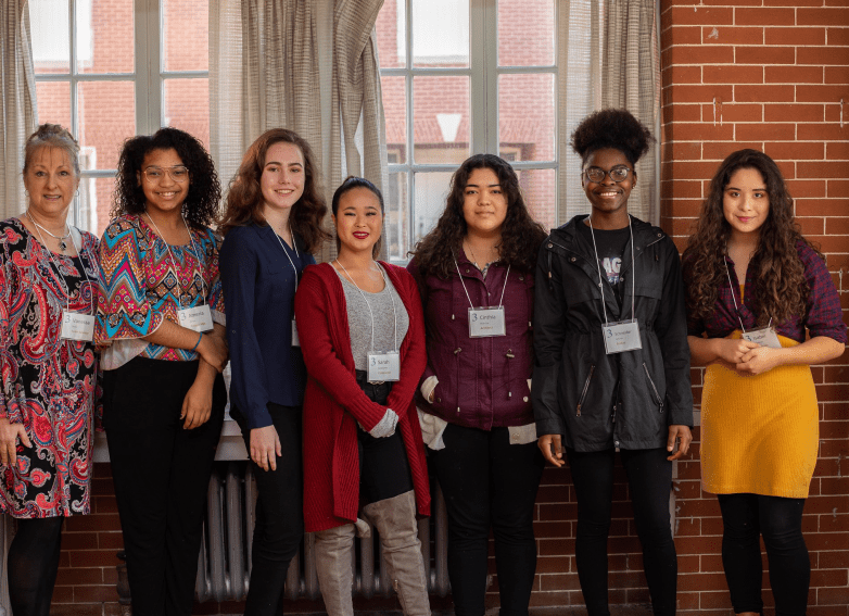 Group photo of students and a businesswoman at a CREW career event