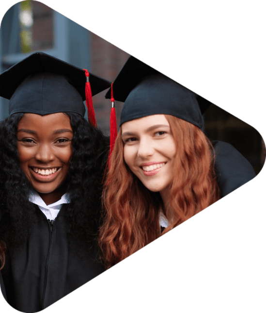 Happy group of mature students on graduation day embracing with each other. Three best girl friends in academic gowns and caps hugging in front of the camera