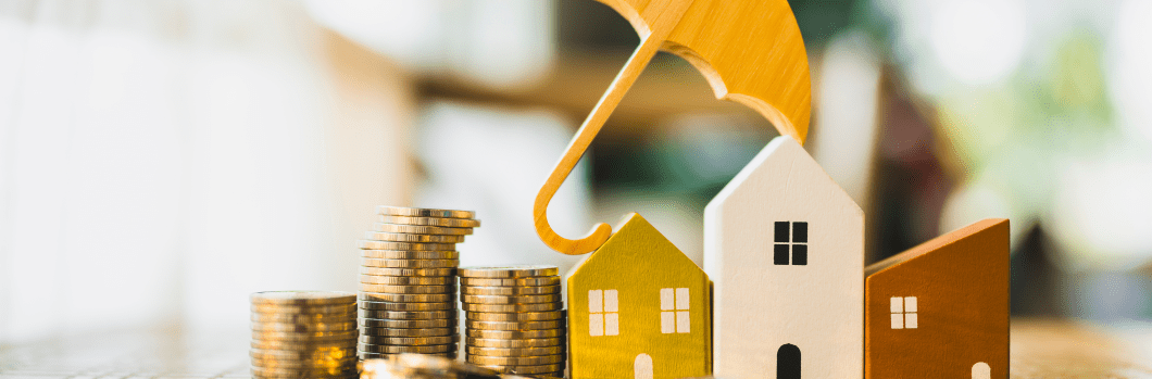 house model and pile of money with an umbrella
