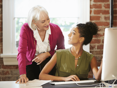 Two Women Working At Computer In Contemporary Office