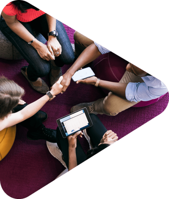 overhead shot of four people meeting and two of them shaking hands